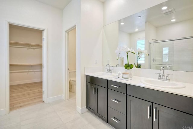 full bath featuring double vanity, a stall shower, visible vents, and a sink