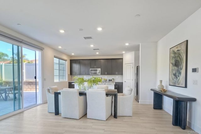 kitchen featuring tasteful backsplash, visible vents, a center island, stainless steel appliances, and light countertops