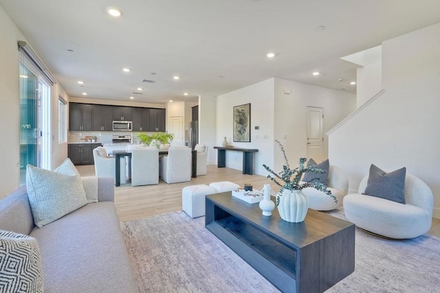 living room with light wood-type flooring and recessed lighting