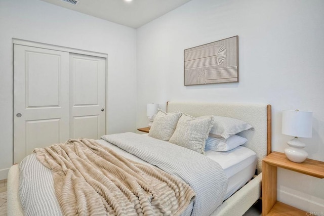 bedroom with light wood finished floors and a closet