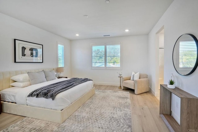 bedroom with light wood finished floors, recessed lighting, visible vents, and baseboards