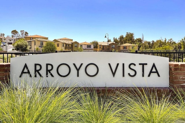 community / neighborhood sign featuring a residential view and fence