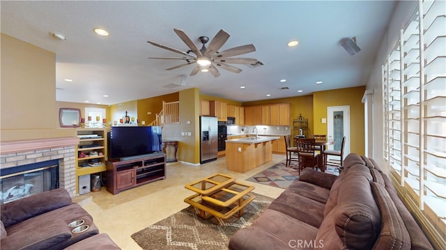 living area with ceiling fan, a fireplace, visible vents, and recessed lighting