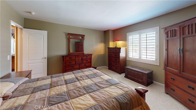 bedroom featuring light carpet and baseboards