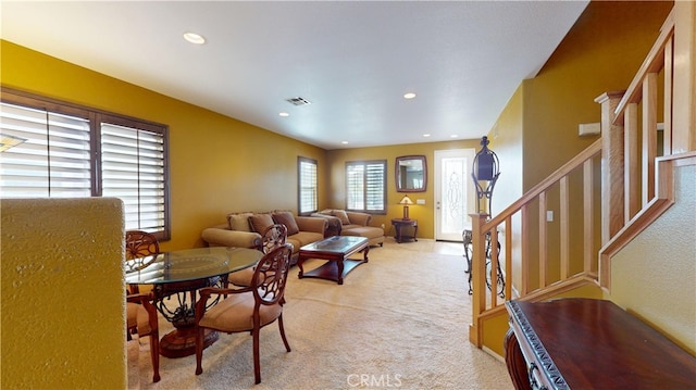 living room featuring recessed lighting, visible vents, light carpet, and stairs