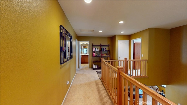 corridor featuring recessed lighting, light colored carpet, attic access, an upstairs landing, and baseboards