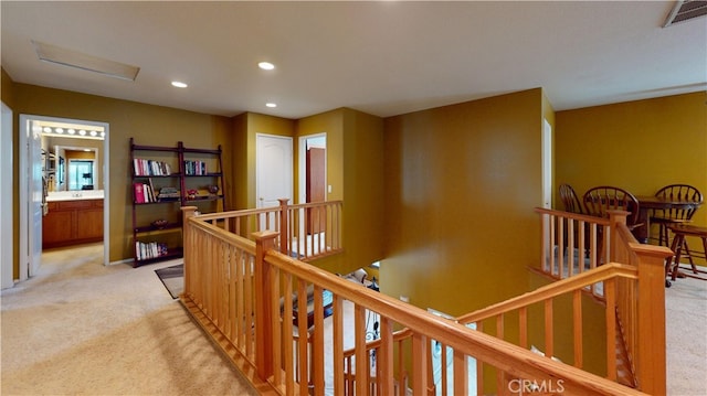 corridor featuring light colored carpet, visible vents, an upstairs landing, and recessed lighting