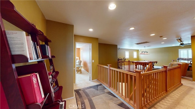 hallway featuring recessed lighting, visible vents, baseboards, and light colored carpet