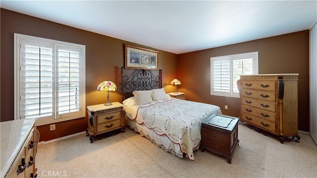 bedroom featuring baseboards and light colored carpet