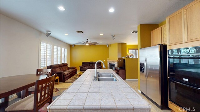11318 Fitzpatrick Dr, Rancho Cucamonga, CA 91730 - kitchen featuring tile counters, stainless steel fridge with ice dispenser, light brown cabinets, a sink, and recessed lighting