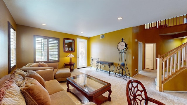 living room with recessed lighting, light colored carpet, visible vents, stairway, and baseboards