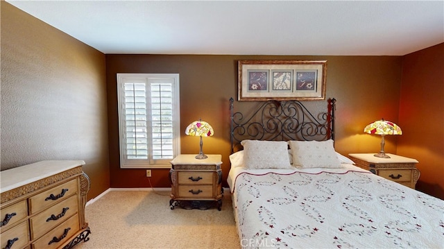 bedroom with light colored carpet and baseboards