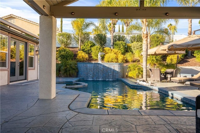 pool with french doors and a patio area