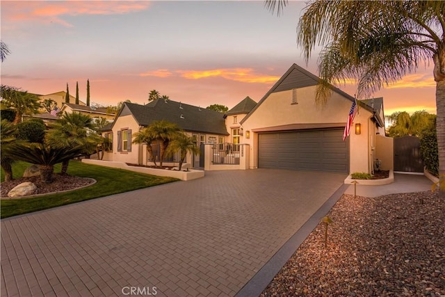 view of front of property with a garage, a gate, decorative driveway, and stucco siding