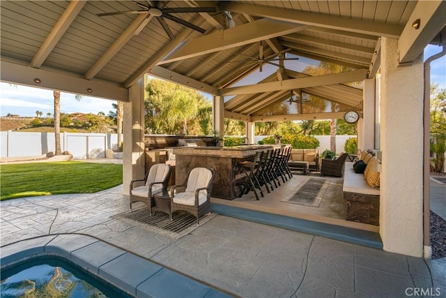 view of patio / terrace featuring a fenced backyard, an outdoor living space, a ceiling fan, outdoor dry bar, and a gazebo