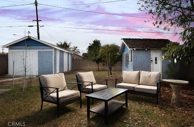 view of patio featuring fence, an outdoor structure, an outdoor hangout area, and a storage unit