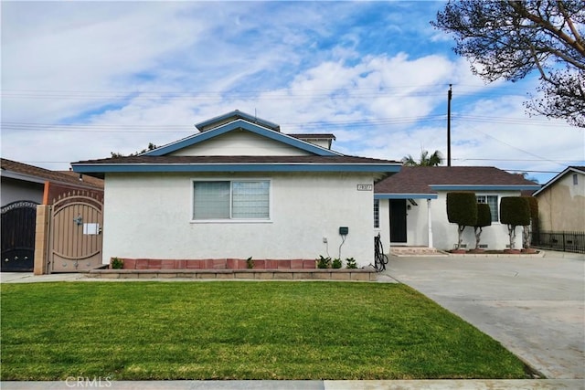 single story home with a gate, a front lawn, and stucco siding