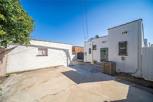 exterior space with fence, cooling unit, and stucco siding