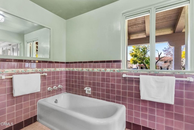 full bathroom with a bath, tile walls, and wainscoting