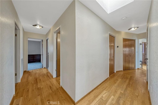 18945 Timber Point Rd, Hidden Valley Lake, CA 95467 - hallway with visible vents, a skylight, and light wood finished floors