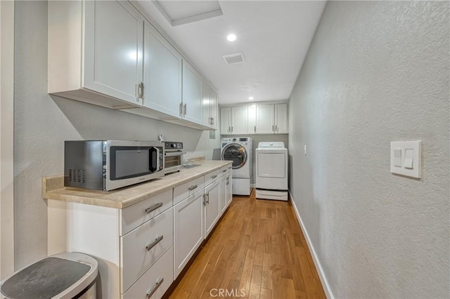 18945 Timber Point Rd, Hidden Valley Lake, CA 95467 - kitchen featuring stainless steel microwave, light countertops, light wood finished floors, washing machine and dryer, and baseboards