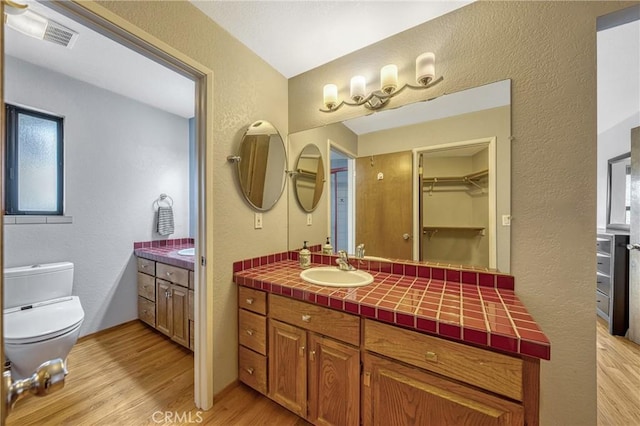 18945 Timber Point Rd, Hidden Valley Lake, CA 95467 - bathroom featuring visible vents, a textured wall, toilet, wood finished floors, and vanity