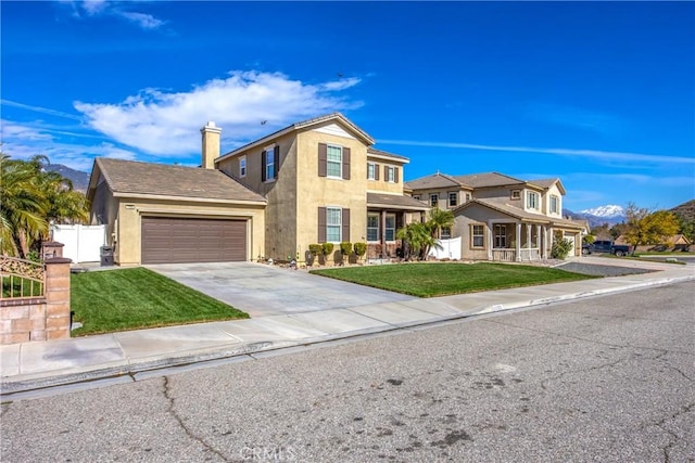 traditional-style home with a garage, driveway, a residential view, and a front yard