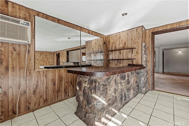 bar featuring light tile patterned floors, wood walls, and a wall mounted AC