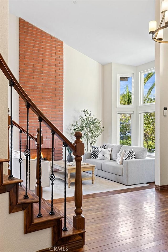 living room with a chandelier, stairway, and wood finished floors