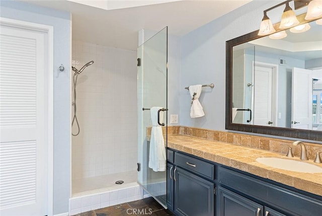 bathroom with a closet, visible vents, a shower stall, and vanity