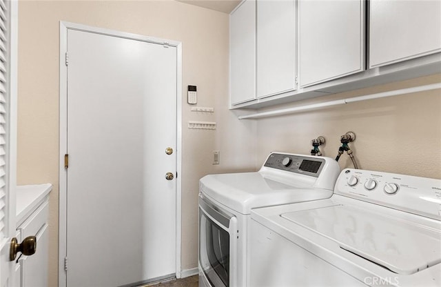 laundry room featuring separate washer and dryer and cabinet space