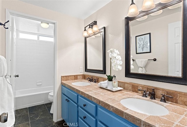 full bathroom featuring double vanity,  shower combination, a sink, and toilet