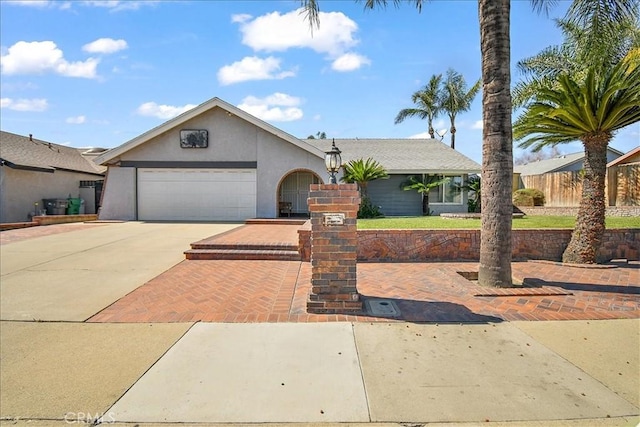 view of front of home featuring a garage, driveway, and stucco siding