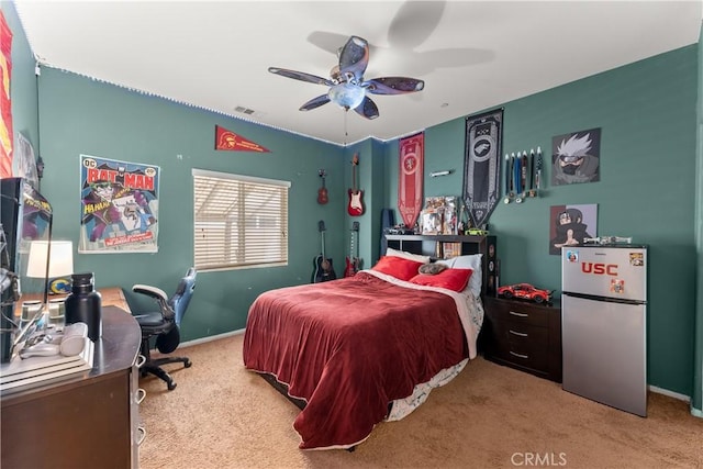 bedroom featuring light carpet, visible vents, freestanding refrigerator, and baseboards