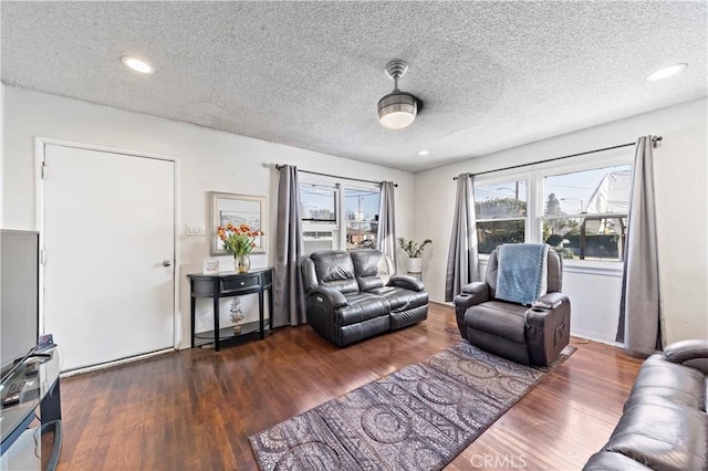 living room with dark wood-style floors, recessed lighting, and a textured ceiling