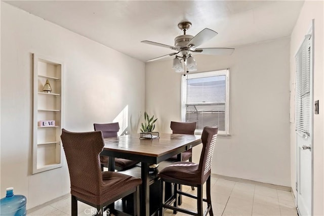 dining space with light tile patterned floors, built in features, and a ceiling fan
