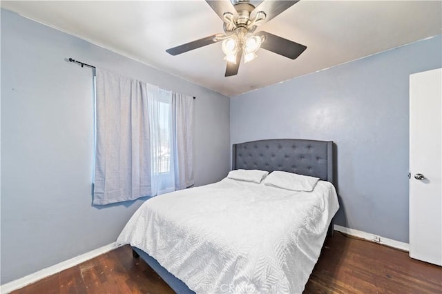 bedroom with ceiling fan, dark wood-type flooring, and baseboards