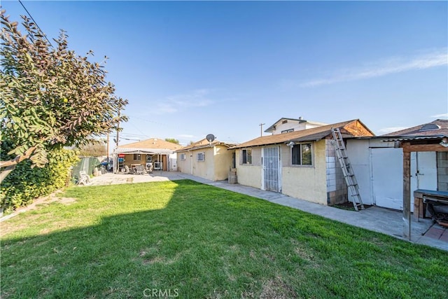 rear view of house featuring a yard, a patio area, and a fenced backyard