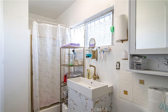 full bath featuring a shower with shower curtain and a sink