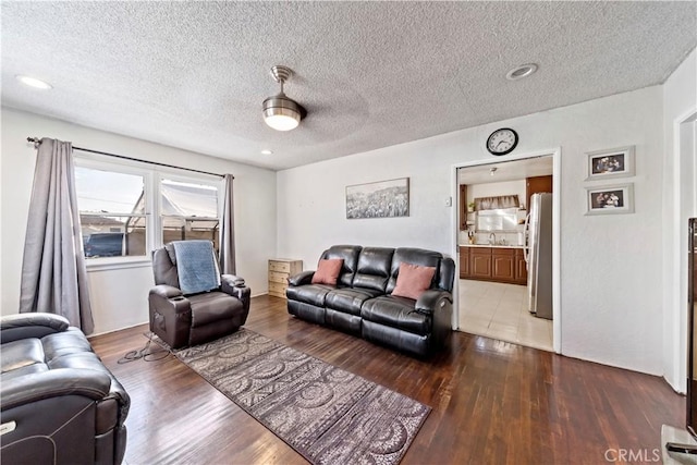 living area featuring a textured ceiling and wood finished floors