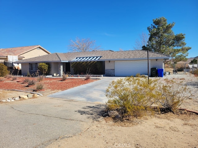 single story home with a garage, stone siding, driveway, and stucco siding