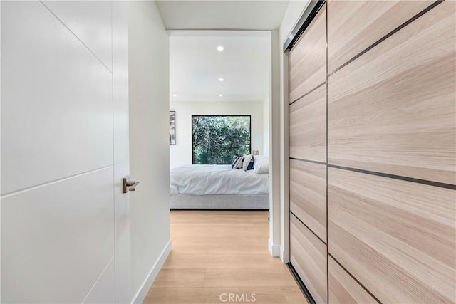 corridor with light wood finished floors and recessed lighting