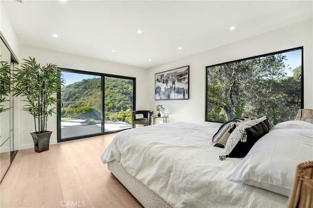 bedroom featuring access to exterior, recessed lighting, and light wood-style flooring