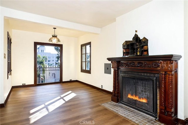 entrance foyer with a fireplace with flush hearth, baseboards, wood finished floors, and beam ceiling