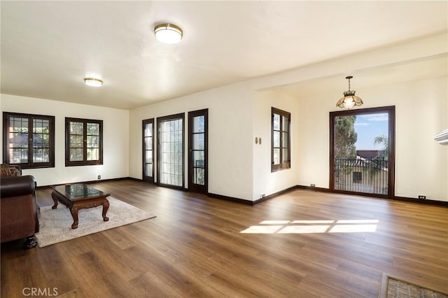 living area featuring baseboards, dark wood-style floors, and plenty of natural light