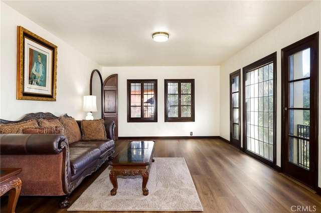 living area with baseboards and dark wood finished floors