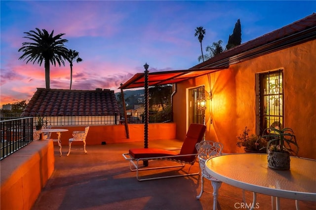 patio terrace at dusk featuring outdoor dining area