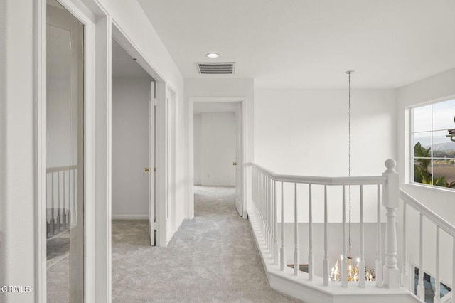 hallway featuring an upstairs landing, recessed lighting, visible vents, and light colored carpet