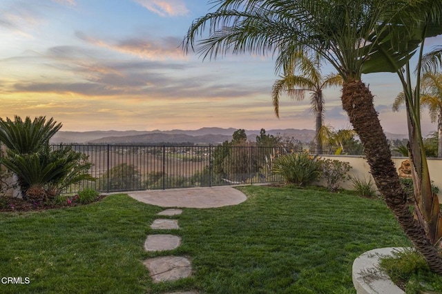 view of yard featuring a patio area, a fenced backyard, and a mountain view