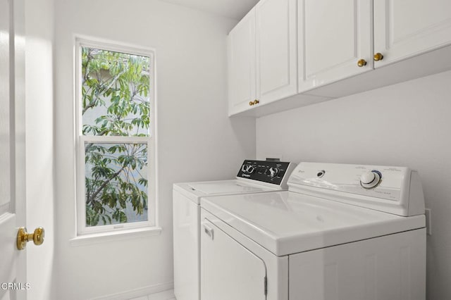 clothes washing area with washer and dryer and cabinet space